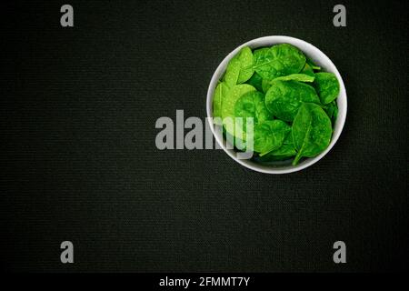 Fresh baby spinach in a black bowl Stock Photo
