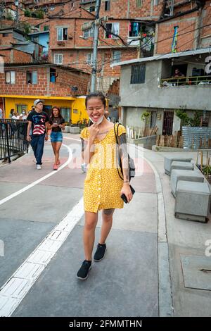 Medellin, Antioquia, Colombia - March 27 2021: Young Asian Woman is Wearing a Yellow Dress and Walking in the Comuna 13, a Touristic Neighbourhood Stock Photo