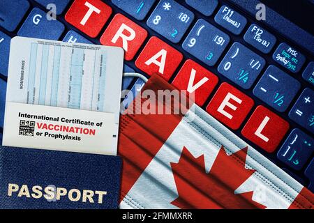 Canada new normal travel concept with passport, boarding pass, face mask with Canadian flag and certificate of COVID-19 vaccination on keyboard. Stock Photo