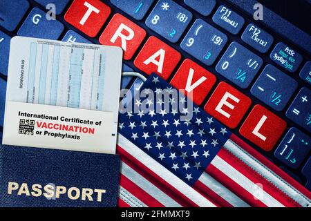 US new normal travel concept with passport, boarding pass, face mask with US flag and certificate of COVID-19 vaccination on keyboard. Vaccine passpor Stock Photo