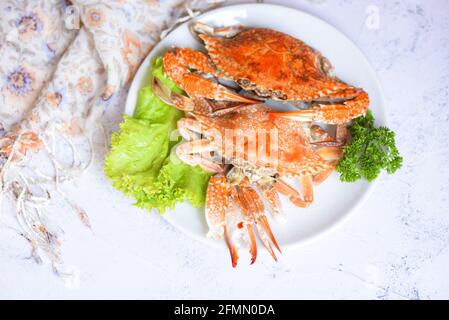 Fresh seafood crab on white plate cooking food in the restaurant, Steamed or boiled Blue Swimming Crab ocean gourmet with salad vegetables lettuce, to Stock Photo