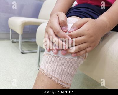 Kid boy feel knee pain after accident, healthy problem concept. Stock Photo