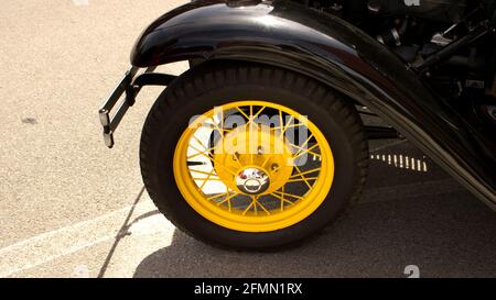 A Bright Yellow Wire Wheel on an Old Car Stock Photo