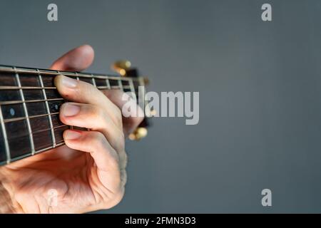 Hand holding guitar chord with copy space on the right Stock Photo