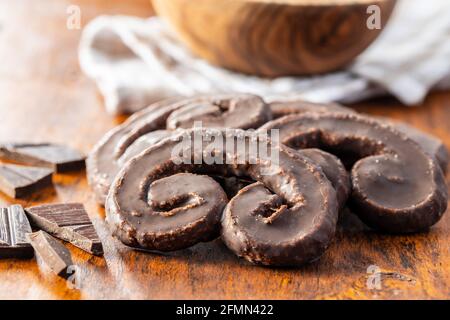 Sweet pastry palmeritas with chocolate icing on wooden table. Stock Photo