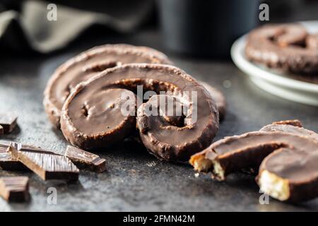 Sweet pastry palmeritas with chocolate icing on black table. Stock Photo