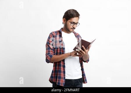Indian college student reading book on white background. Stock Photo