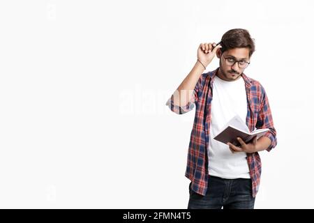 Young handsome indian college student giving thinking expression on white background Stock Photo