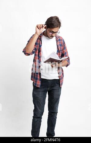 Young handsome indian college student giving thinking expression on white background Stock Photo