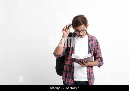 Young handsome indian college student giving thinking expression on white background Stock Photo