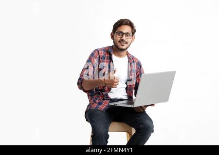 Indian college student using laptop on white background. Stock Photo