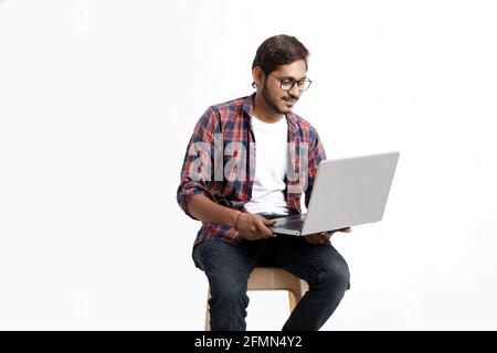 Indian college student using laptop on white background. Stock Photo