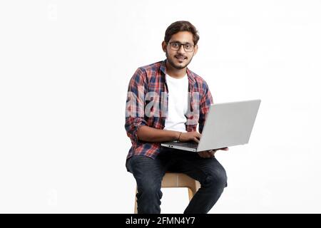Indian college student using laptop on white background. Stock Photo