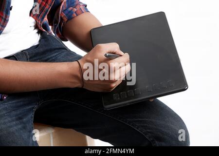 Professional designer using graphic tablet connected to smartphone with digital pen. Stock Photo