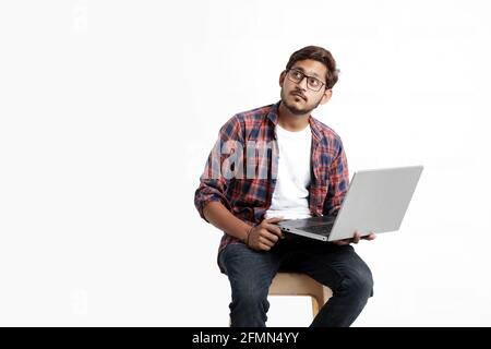 Young indian man thinking some idea when working on laptop. Stock Photo