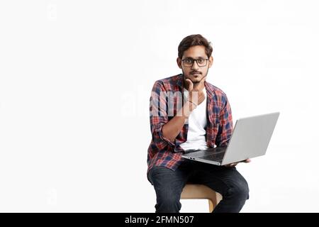 Young indian man thinking some idea when working on laptop. Stock Photo