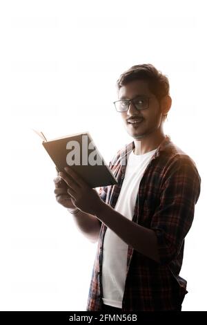 Indian college student reading book on white background. Stock Photo