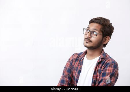 Young handsome indian college student giving thinking expression on white background Stock Photo