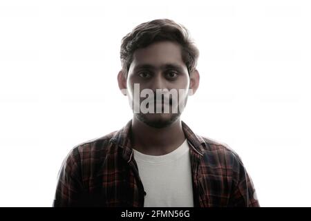 Young Indian man standing on white background. Stock Photo
