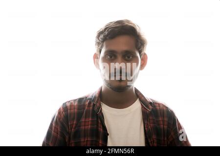 Young Indian man standing on white background. Stock Photo