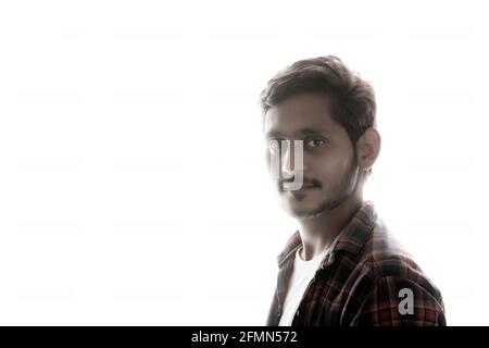 Young Indian man standing on white background. Stock Photo