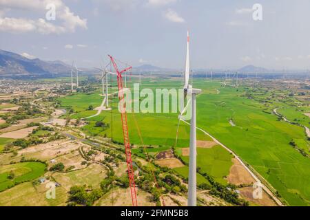 Wind turbine being repaired, assisted by crane and elevator. Wind power plant. green meadow with Wind turbines generating electricity Stock Photo