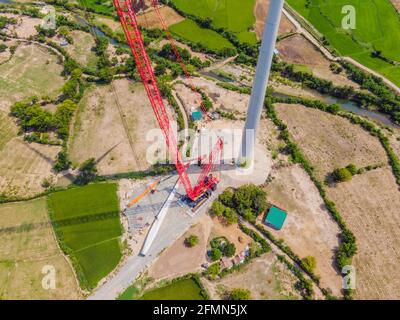 Wind turbine being repaired, assisted by crane and elevator. Wind power plant. green meadow with Wind turbines generating electricity Stock Photo