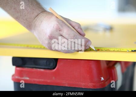 Close-up of qualified construction site worker using pencil for notes Stock Photo