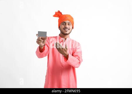 Young indian farmer showing card on white background Stock Photo