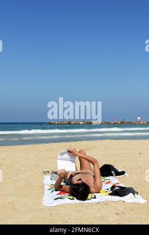Sunbathing on the beautiful beach in Tel-Aviv. Stock Photo