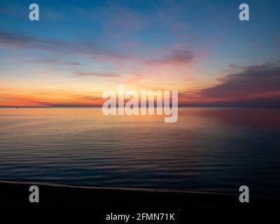 Sunset over Port Phillip Bay with sailing boats in the distance Stock Photo