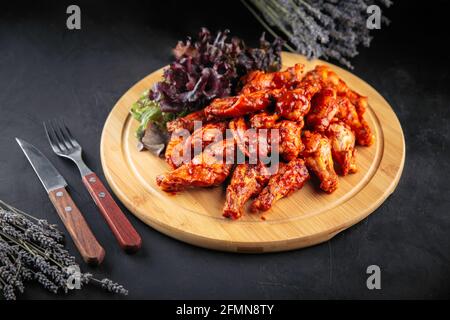 Plate of spicy fried chicken wings with salad