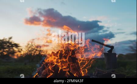 evening bonfire and ax on the background of the sunset sky Stock Photo