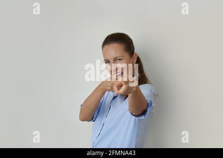 Woman winking and pointing with finger at camera Stock Photo