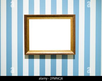 gold painted wooden picture frame with cutout canvas on blue striped wall Stock Photo