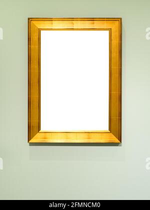 vertical flat gold wooden picture frame with cutout canvas on vertical light green wall Stock Photo