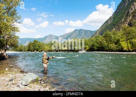 Fishing by flyfishing on the river. Russia Siberia. River Chelushman Stock Photo