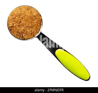 top view of granulated coconut blossom sugar in steel measuring tablespoon cutout on white background Stock Photo