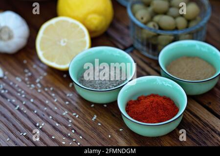 Oriental spices cumin, ground zira and red pepper paprika in bowls on a wooden oak table. Soft selective focus. Stock Photo