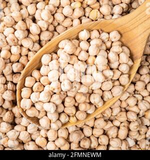 top view of chickpea seeds in wooden spoon closeup Stock Photo