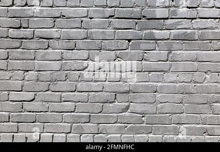 Black weathered red brick wall as background texture. Bricks masonry with uneven seams Stock Photo