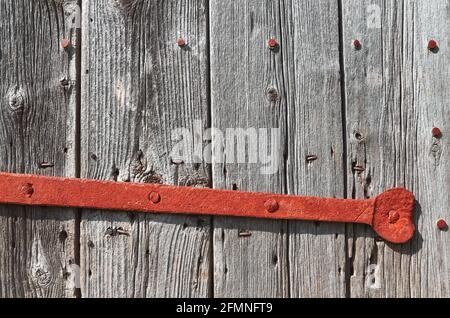 Close up picture of an old wooden door with rusty lock bar. Stock Photo
