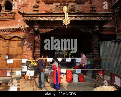 Kathmandu, Bagmati, Nepal. 11th May, 2021. People pay homage to their mothers at the gate of a temple on Mother's Day, or Mata Tirtha Aunsi, as temple is closed due to prohibitory orders amid the increasing number of COVID-19 cases in Kathmandu, Nepal on May 11, 2021. Nepali people observe this day to show respect to their mothers and to pay homage to the departed mothers. Credit: Sunil Sharma/ZUMA Wire/Alamy Live News Stock Photo