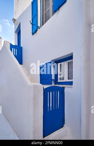 Traditional Greek house on Cyclades or Aegean islands. Whitewashed walls and dark blue doors, shutters and window frames. Colors of Greece. Stock Photo