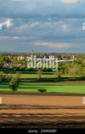 Scenic rural & urban view over flat sunlit farmland fields & Tadcaster town (brewery buildings, houses) - Vale of York, North Yorkshire, England, UK. Stock Photo