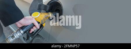 Close up of man pumping fuel in car at gas station. Pumping gas web banner. Stock Photo