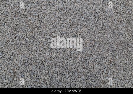 Dry white limestone ballast flat full frame background. Small gray dusty broken macadam stones texture. Viiew from above. Stock Photo