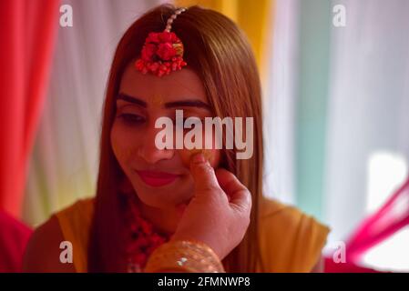 portrait of beautiful indian bride with turmeric haldi paste on her face. Stock Photo