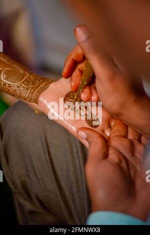 close up of hands of stunning indian bride,applying hinna on her wedding. Stock Photo