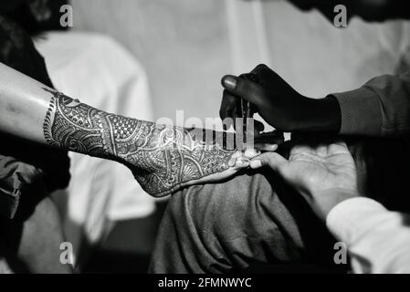 close up of legs of stunning indian bride,applying hinna on her wedding. Stock Photo